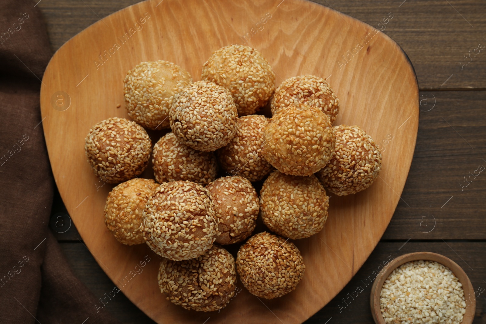 Photo of Delicious sesame balls on wooden table, flat lay