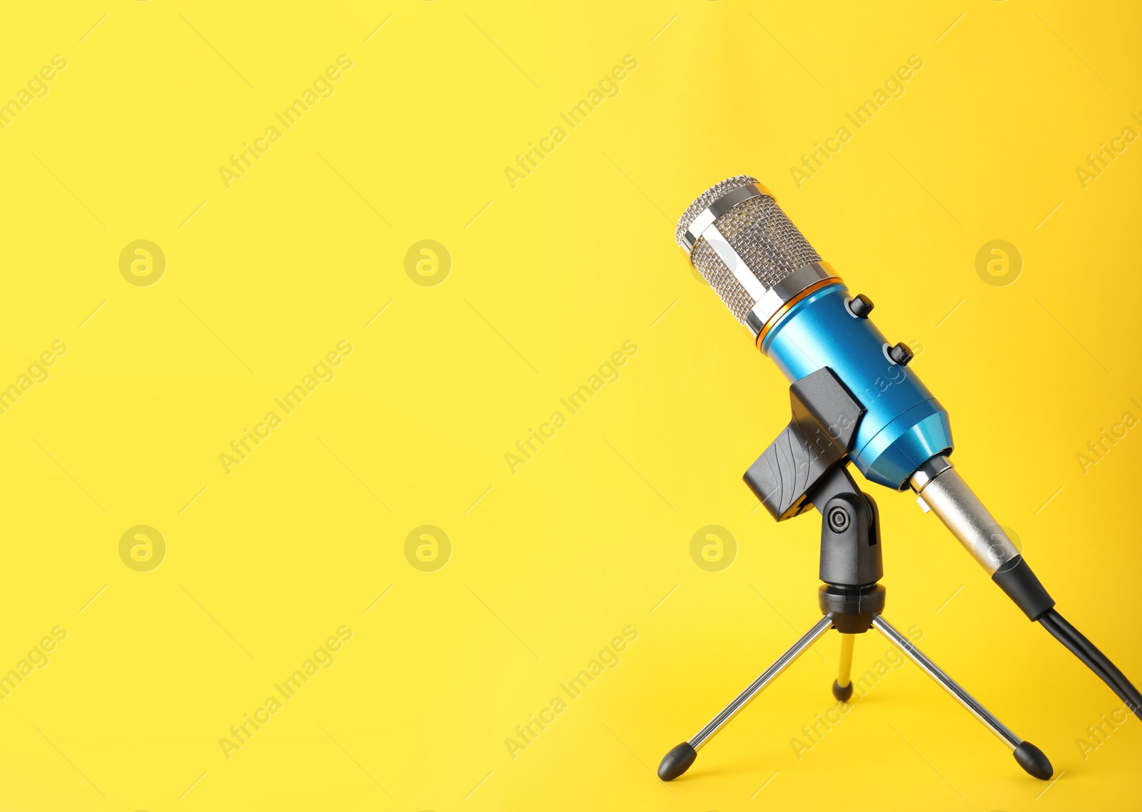 Photo of Condenser microphone on color background, space for text