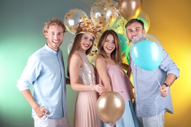 Photo of Friends with air balloons on color background