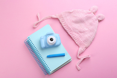 Flat lay composition with little photographer's toy camera on pink background