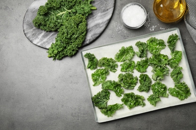 Raw cabbage leaves with seeds on grey table, flat lay. Preparing kale chips