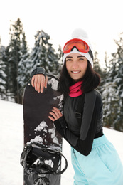 Photo of Young snowboarder wearing winter sport clothes outdoors