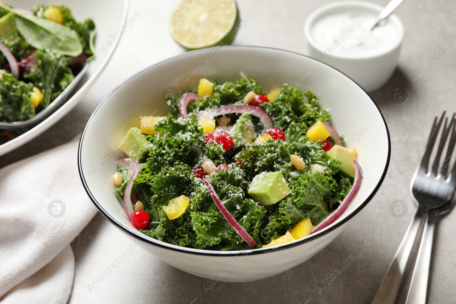 Photo of Tasty fresh kale salad on grey table, closeup