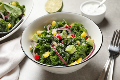 Photo of Tasty fresh kale salad on grey table, closeup