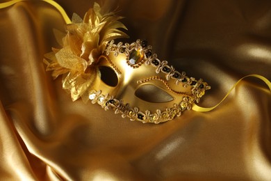 Photo of Beautifully decorated face mask on golden fabric. Theatrical performance