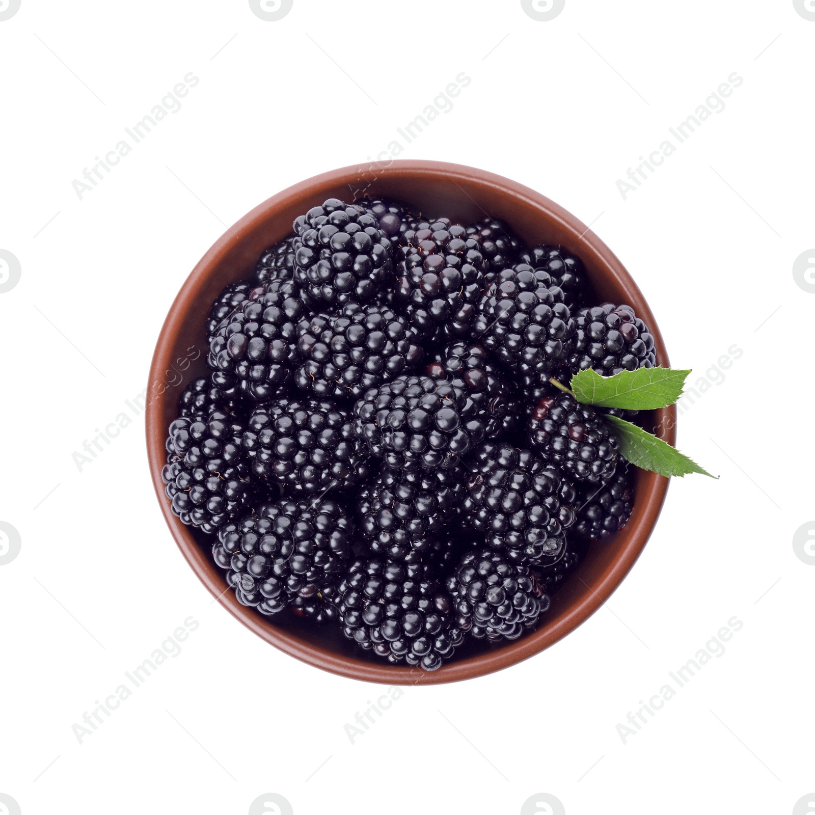 Photo of Brown bowl of tasty ripe blackberries with leaves on white background, top view