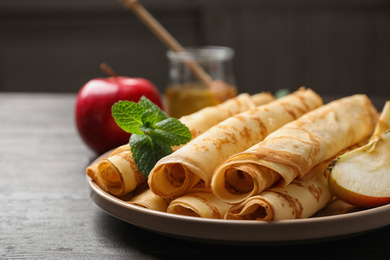 Delicious rolled thin pancakes on wooden table