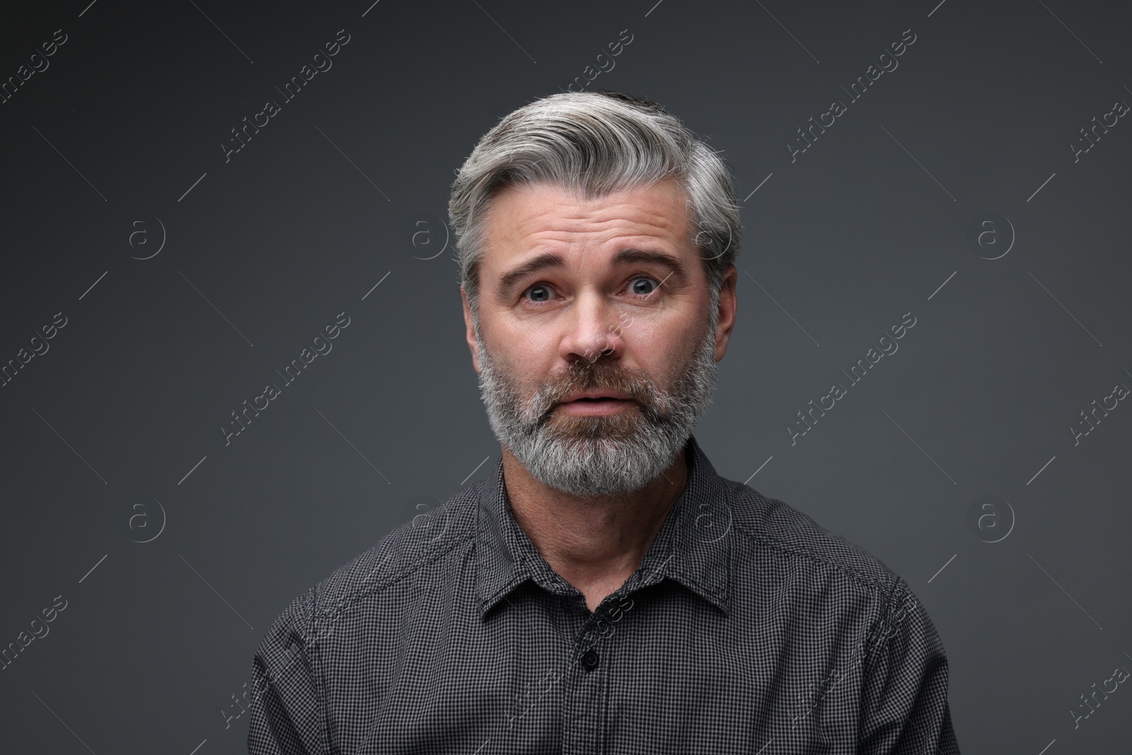 Photo of Personality concept. Portrait of emotional man on dark grey background