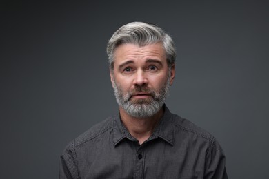 Photo of Personality concept. Portrait of emotional man on dark grey background