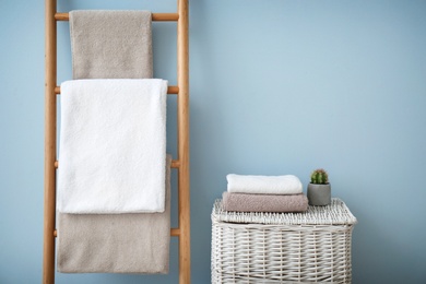 Photo of Clean towels on holder and wicker basket in bathroom