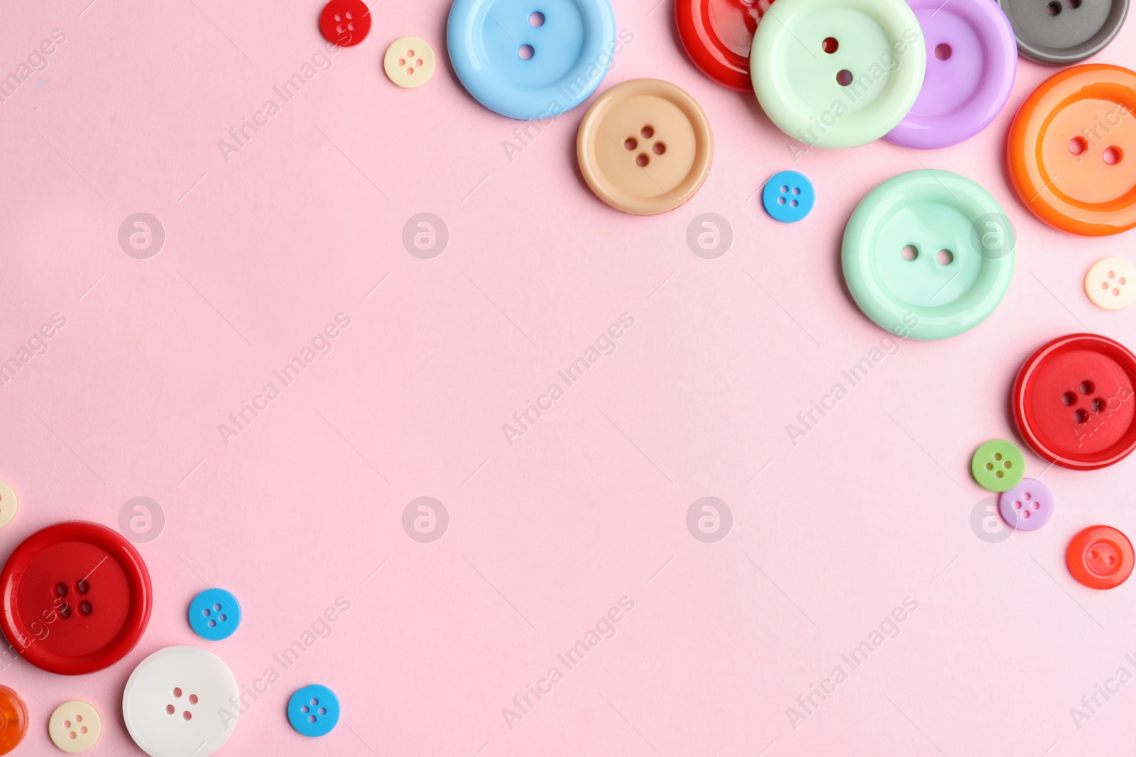 Photo of Many sewing buttons on pink background, flat lay. Space for text