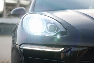 Modern black car parked outdoors, closeup view