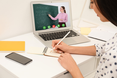 Young woman using laptop for online studying at home, closeup