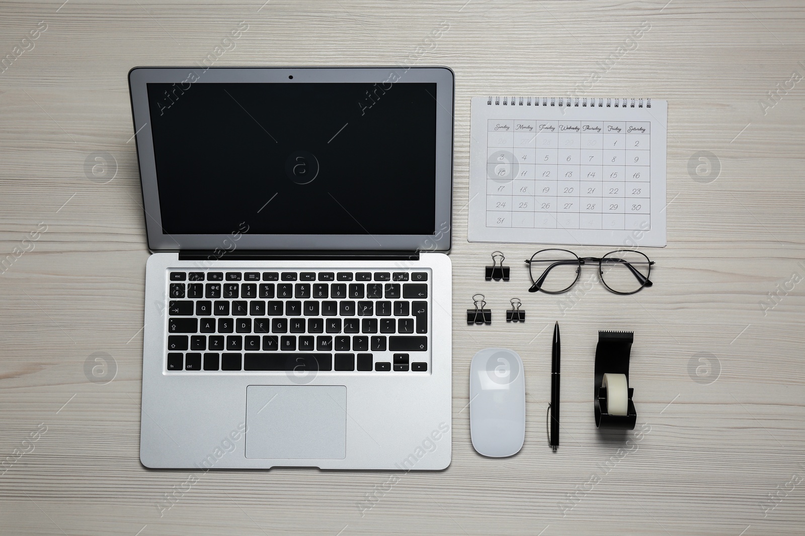 Photo of Modern laptop, glasses and office stationery on white wooden table, flat lay. Distance learning