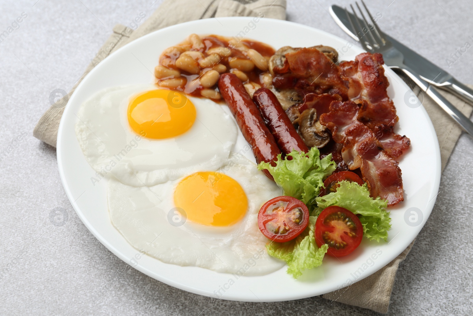 Photo of Delicious breakfast with sunny side up eggs on light table, closeup