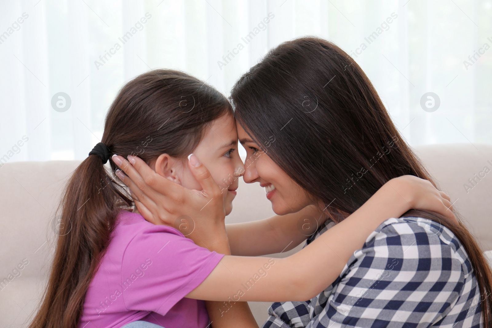 Photo of Happy mother and daughter touching foreheads at home. Single parenting