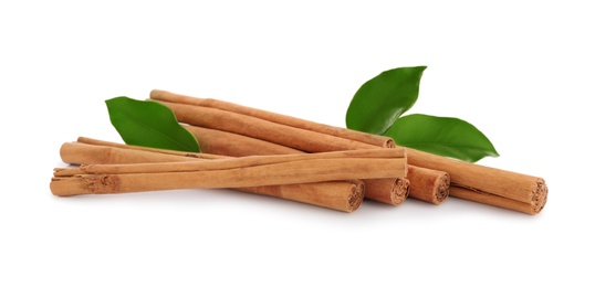 Photo of Aromatic dry cinnamon sticks and green leaves on white background