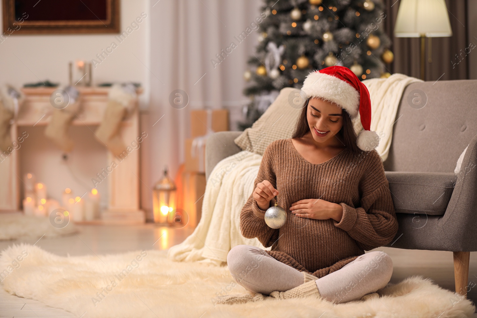 Photo of Happy pregnant woman with Christmas ball at home. Expecting baby