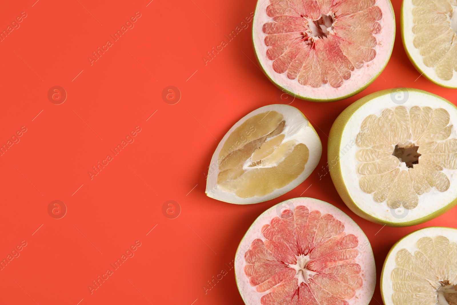 Photo of Fresh cut pomelo fruits on red background, flat lay. Space for text