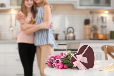 Photo of Gift box, bouquet and happy family on background. Happy Mother's Day