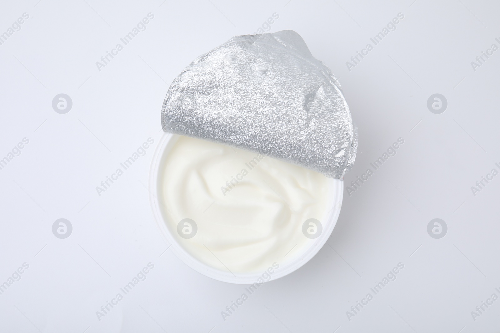 Photo of Delicious natural yogurt in plastic cup isolated on white, top view