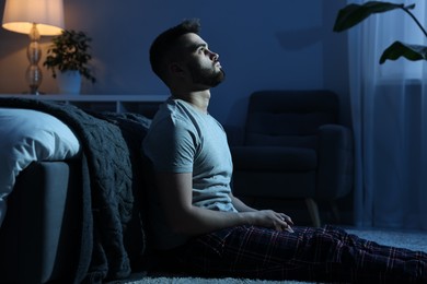 Photo of Man suffering from insomnia in bedroom at night