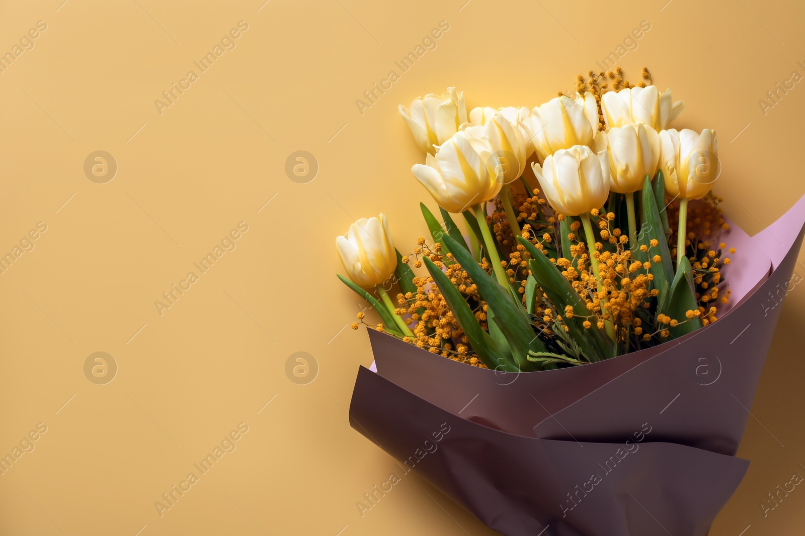 Photo of Bouquet with beautiful tulips and mimosa flowers on yellow background, top view. Space for text