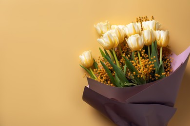 Bouquet with beautiful tulips and mimosa flowers on yellow background, top view. Space for text