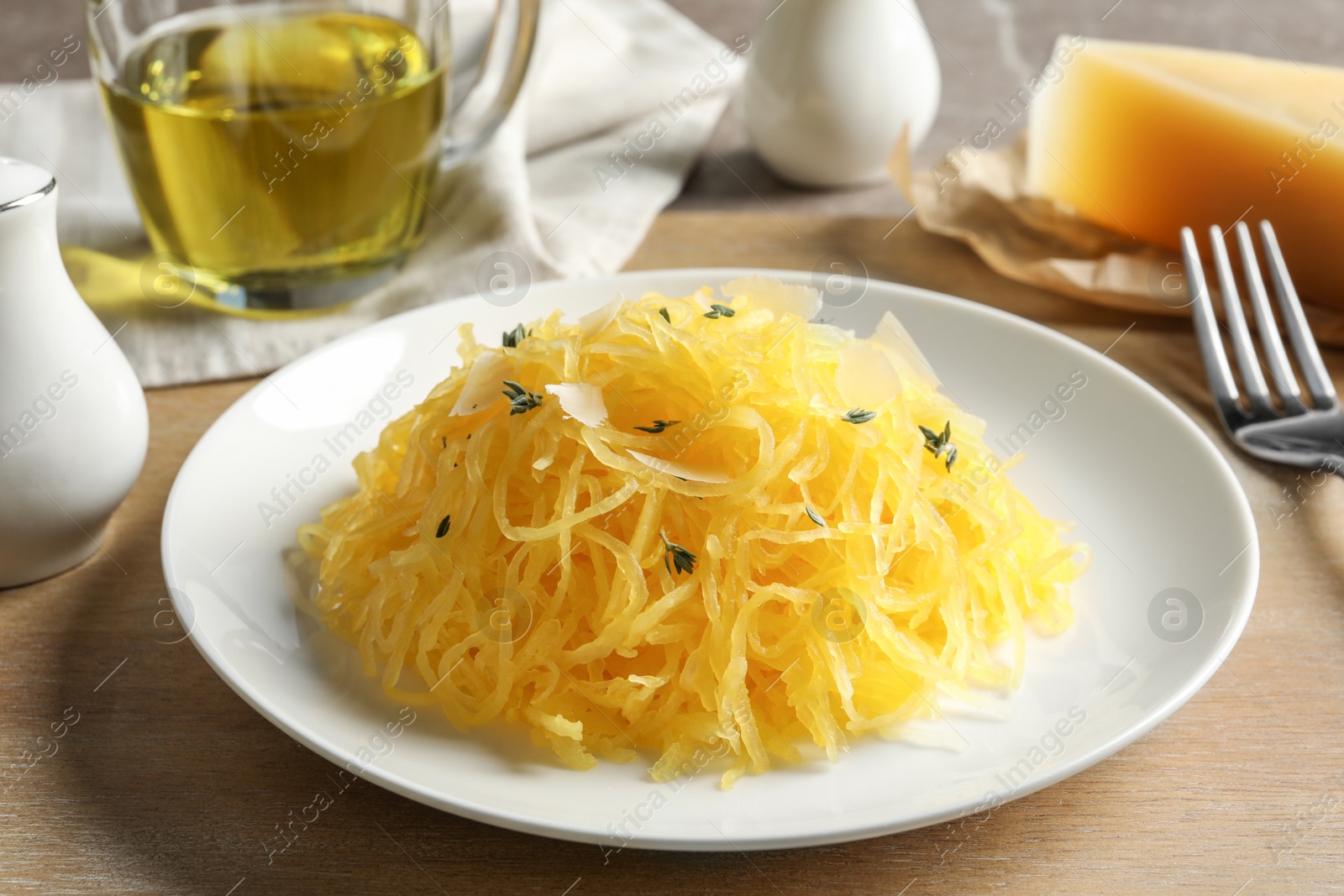 Photo of Plate with cooked spaghetti squash on wooden board