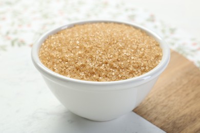 Photo of Brown sugar in bowl on table, closeup