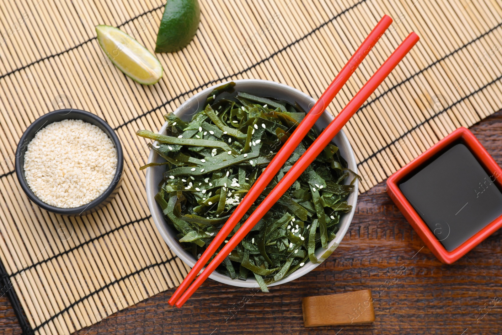 Photo of Fresh laminaria (kelp) seaweed served on wooden table, flat lay