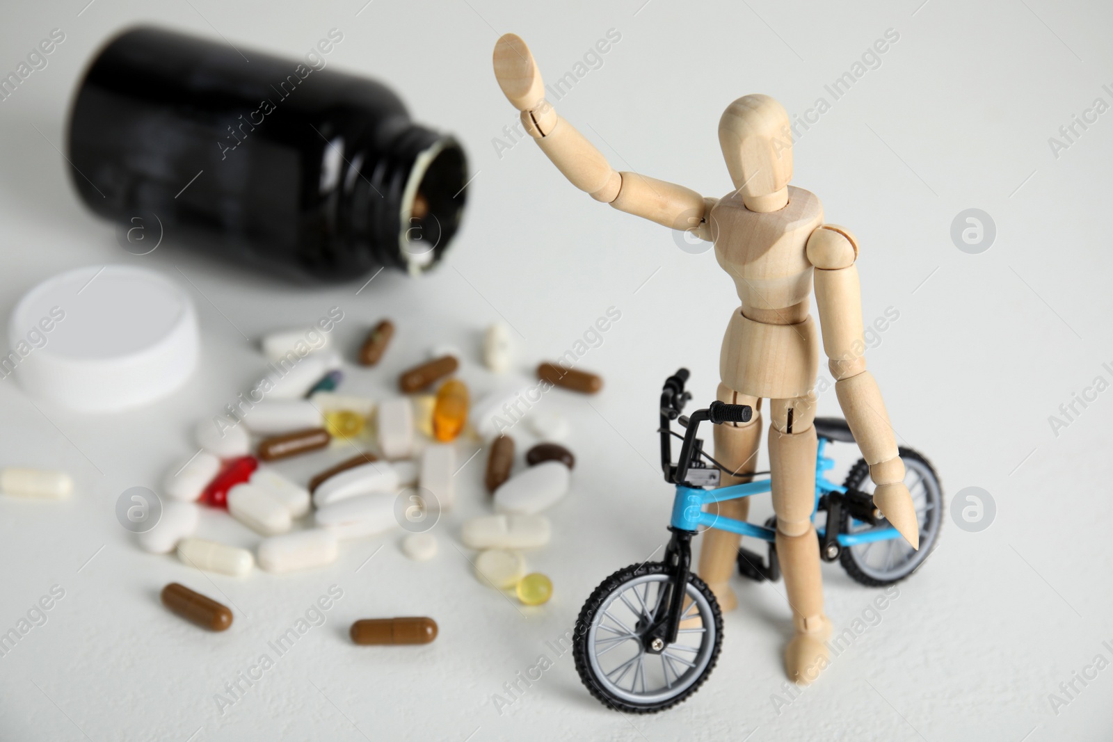 Photo of Pills, sportsman and bike model on white table. Using doping in cycling sport concept