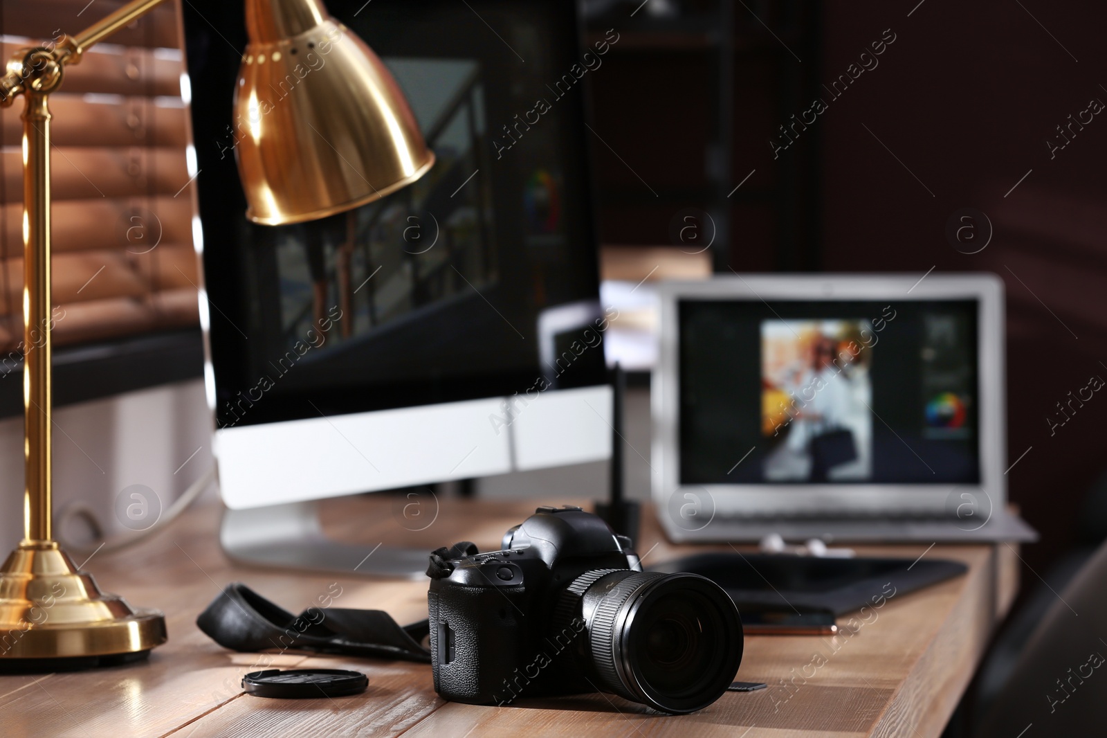 Photo of Retoucher's workplace. Professional camera and lamp on table indoors