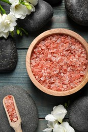 Photo of Sea salt, beautiful flowers and spa stones on blue wooden table, flat lay