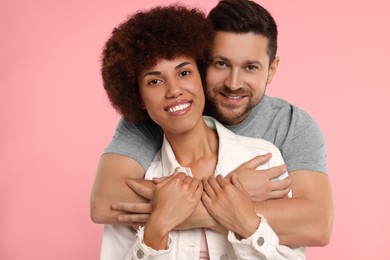 Photo of International dating. Happy couple hugging on pink background