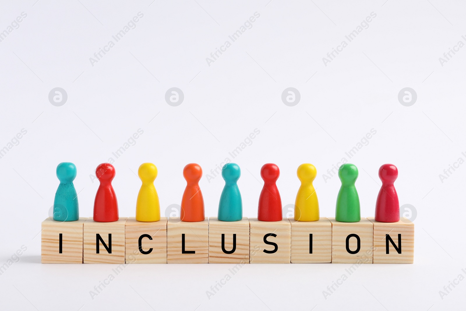 Photo of Colorful pawns and cubes with word Inclusion on white background