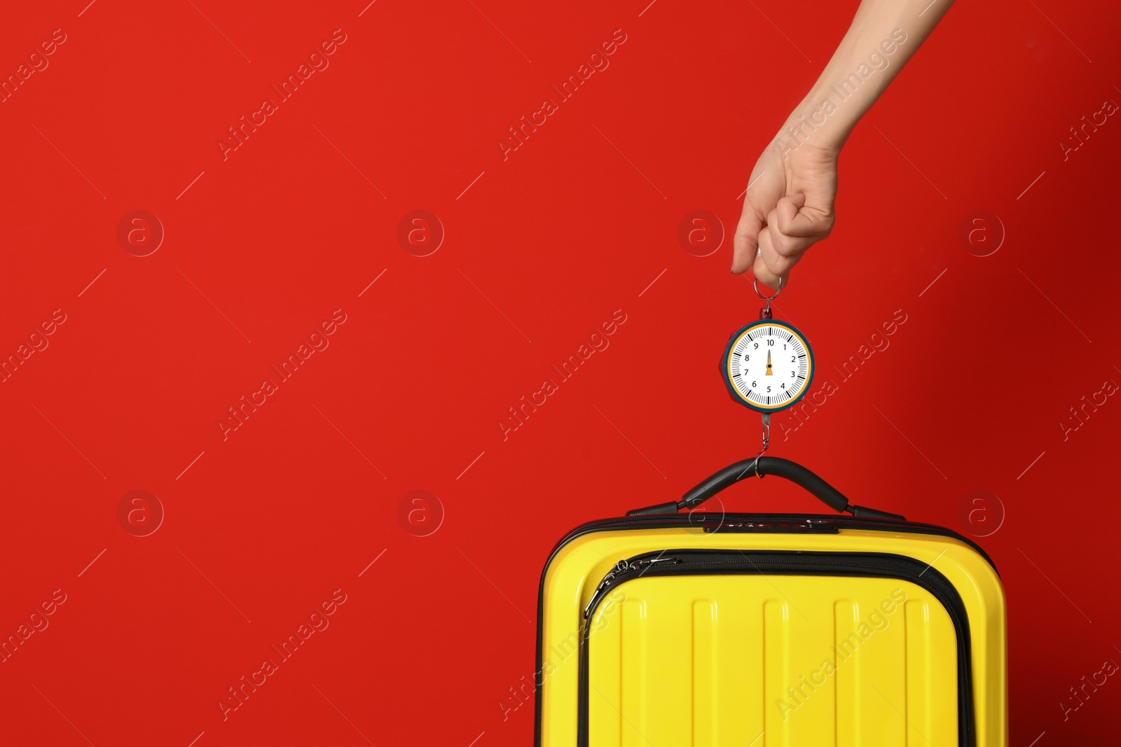 Photo of Woman weighing suitcase against color background, closeup. Space for text