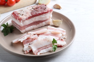 Tasty salt pork with parsley on white wooden table, closeup