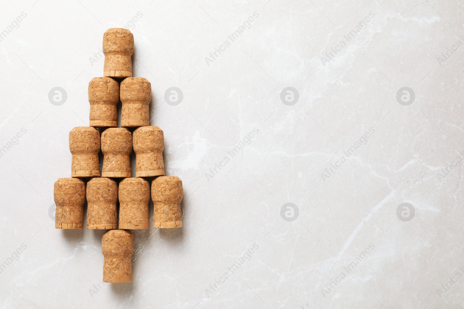 Photo of Christmas tree made of wine corks on beige table, top view. Space for text