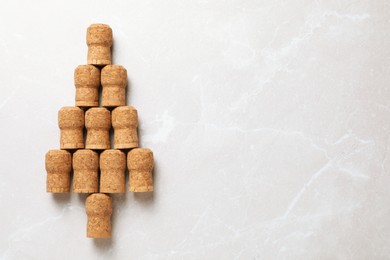 Photo of Christmas tree made of wine corks on beige table, top view. Space for text