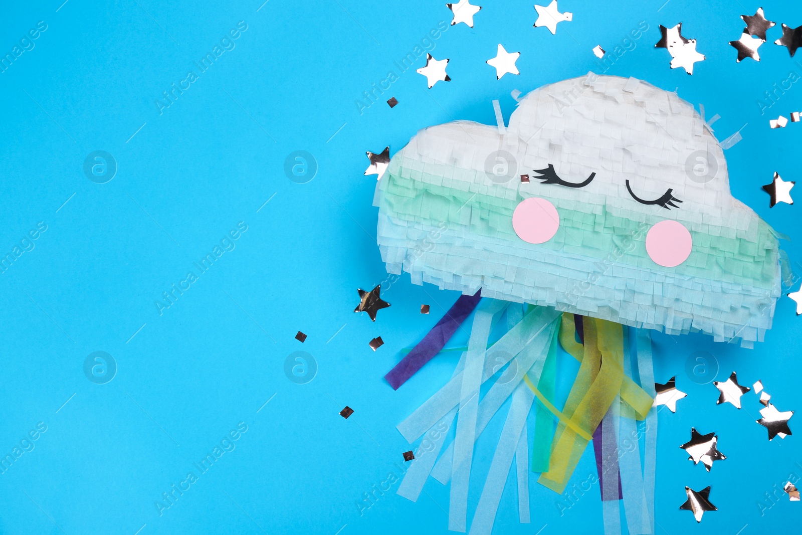 Photo of Bright cloud pinata and confetti on light blue background, flat lay. Space for text