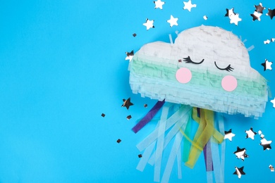 Bright cloud pinata and confetti on light blue background, flat lay. Space for text