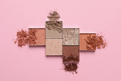Crushed eye shadows on pink background, flat lay. Professional makeup product
