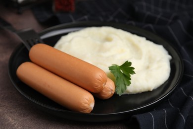 Photo of Delicious boiled sausages, mashed potato and parsley on brown table, closeup