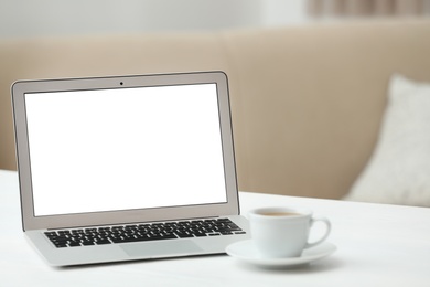 Laptop with blank screen on table indoors. Space for text