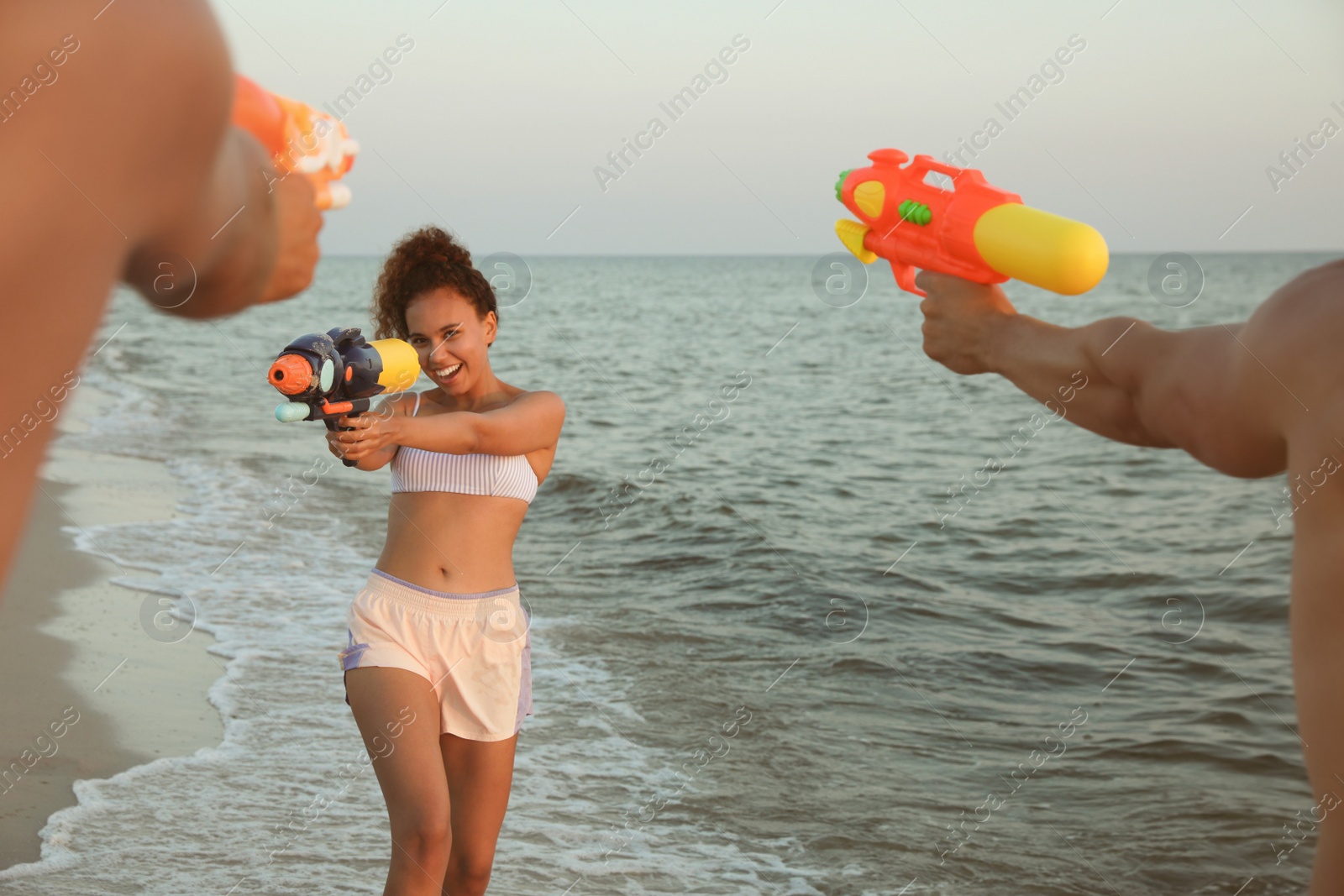 Photo of Friends with water guns having fun on beach