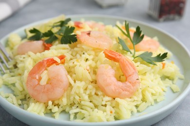 Photo of Delicious risotto with shrimps and parsley on table, closeup