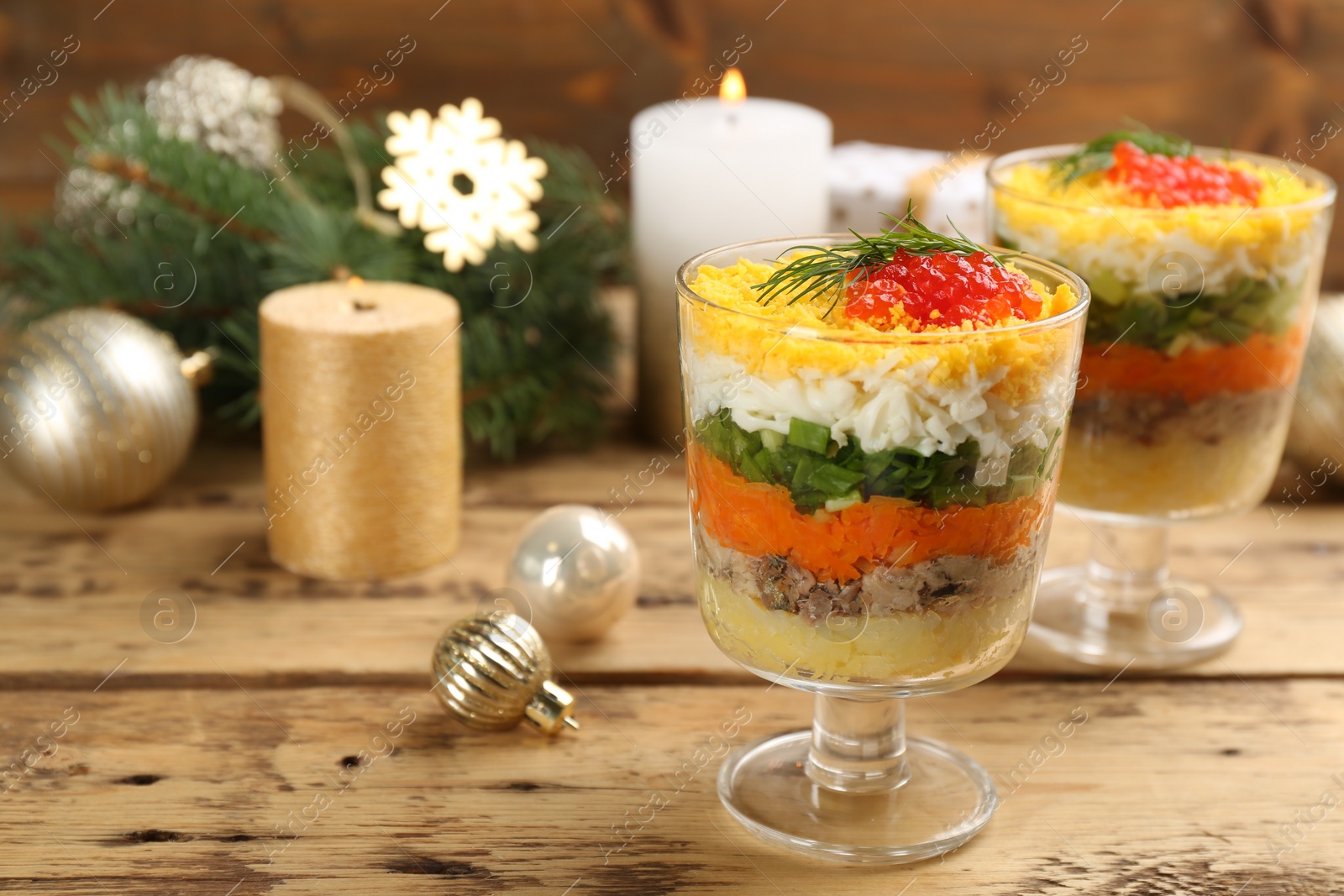 Photo of Traditional russian salad Mimosa and festive decor on wooden table. Space for text