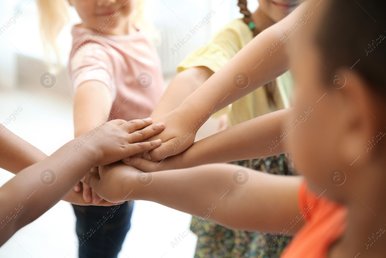 Photo of Little children putting their hands together, closeup. Unity concept