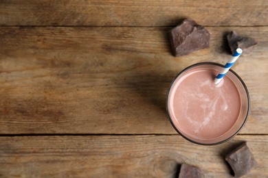 Photo of Delicious chocolate milk on wooden table, flat lay. Space for text